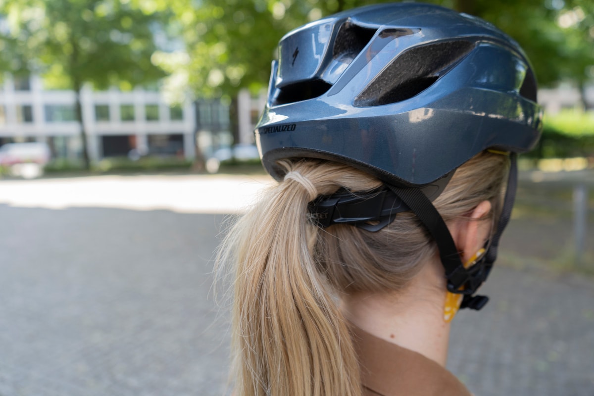 Frau trägt Zopf unterm Align 2-Helm von hinten