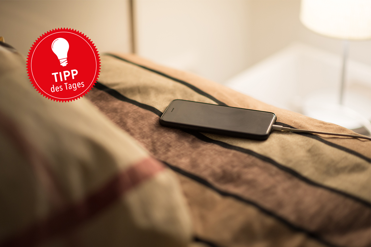 Smartphone liegt auf einem Bett