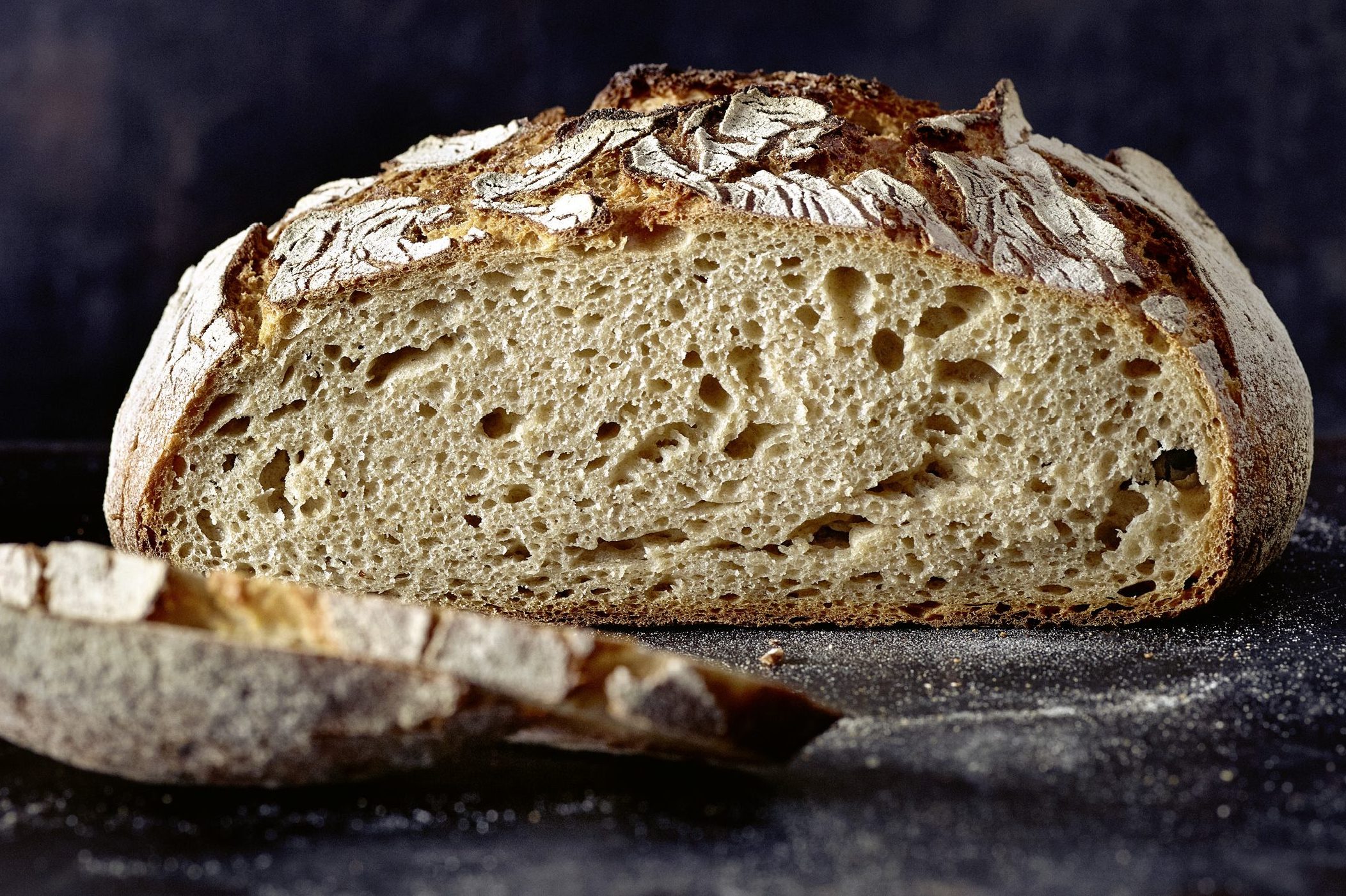 Angeschnittenes Brot von der Seite vor schwarzem Hintergrund