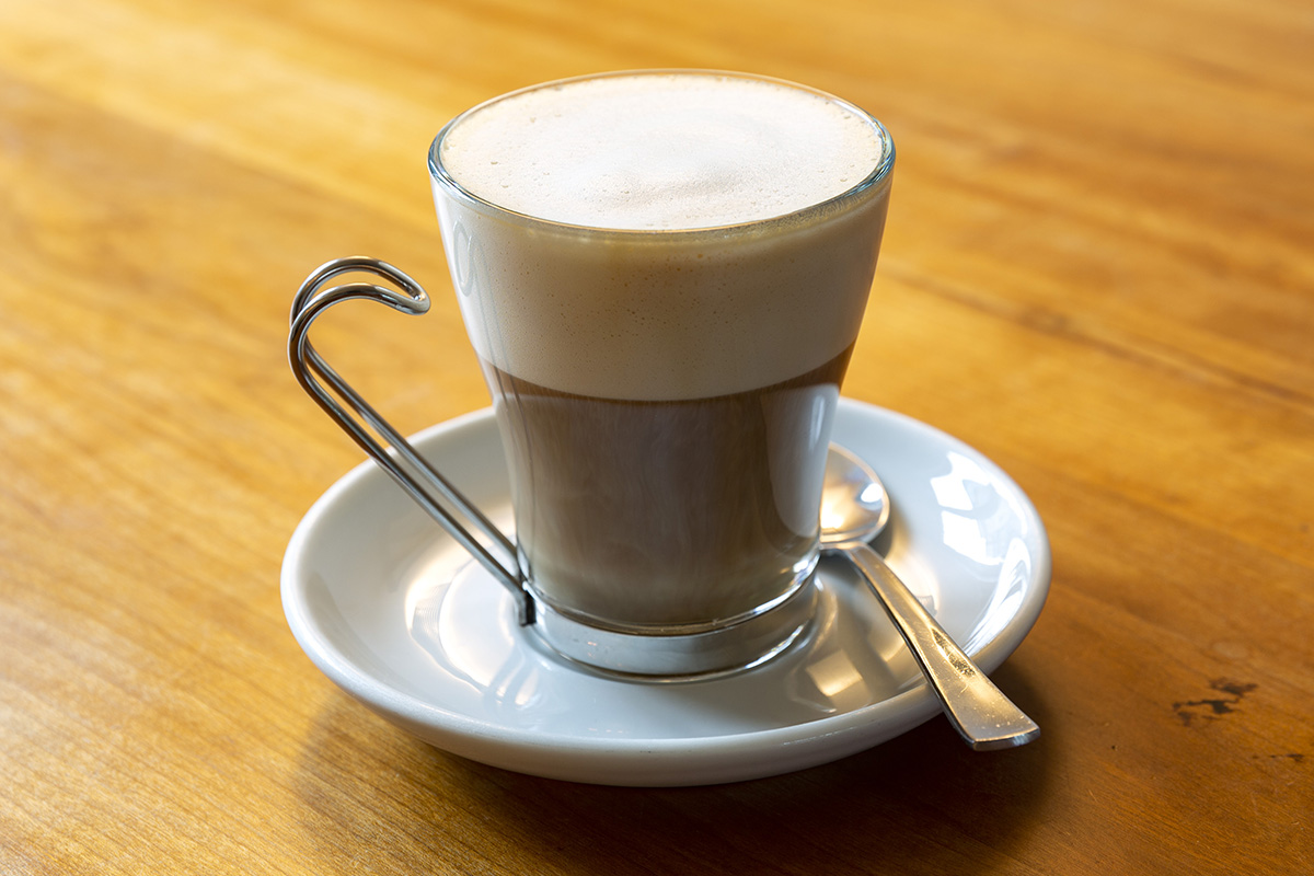 Cappucciono in Becher auf Holztisch mit flachem Schaum