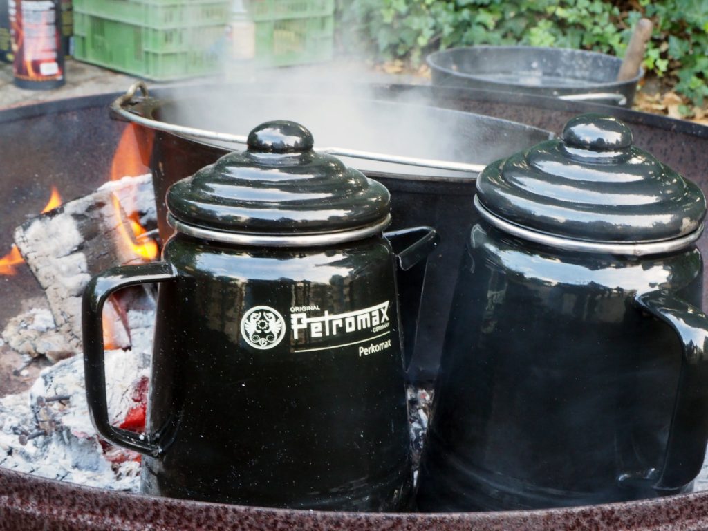 Schwarze Guseiserne Gefäße mit Deckel in Feuerschale