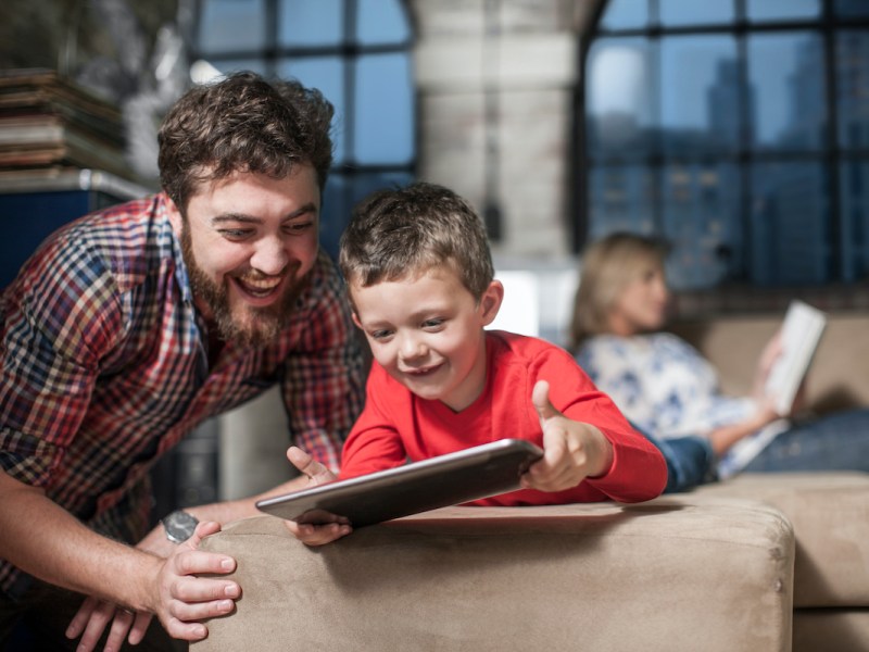 Vater und Sohn spielen auf einem Tablet