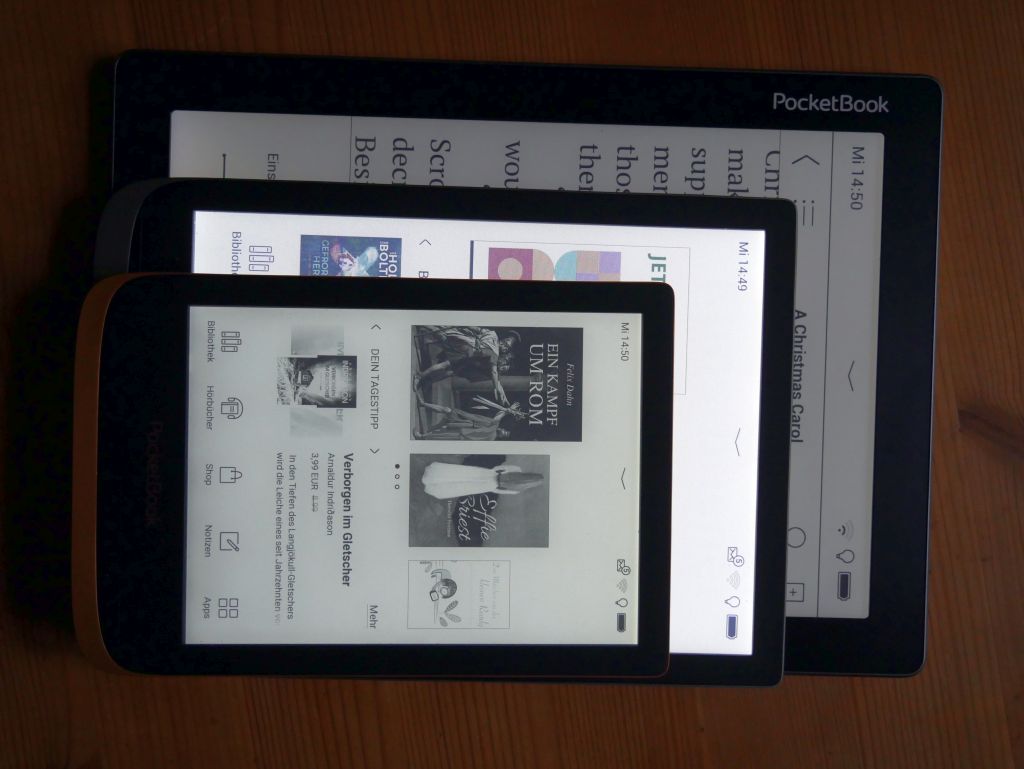 Drei verschieden große eBook-reader hintereinander aufgestellt mit leuchtenden Displays in dunkler Umgebung