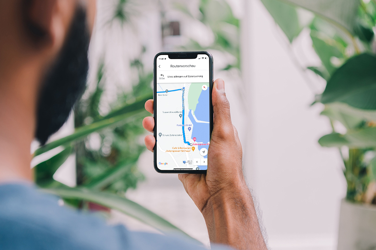 Hand die ein Smartphone hält, mit geöffneter Navigation.