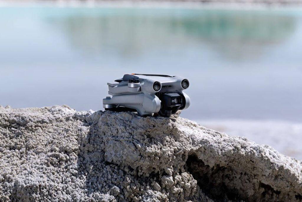 Die Drohne Dji Mini 3 Pro steht auf einem Stein vor einem See.