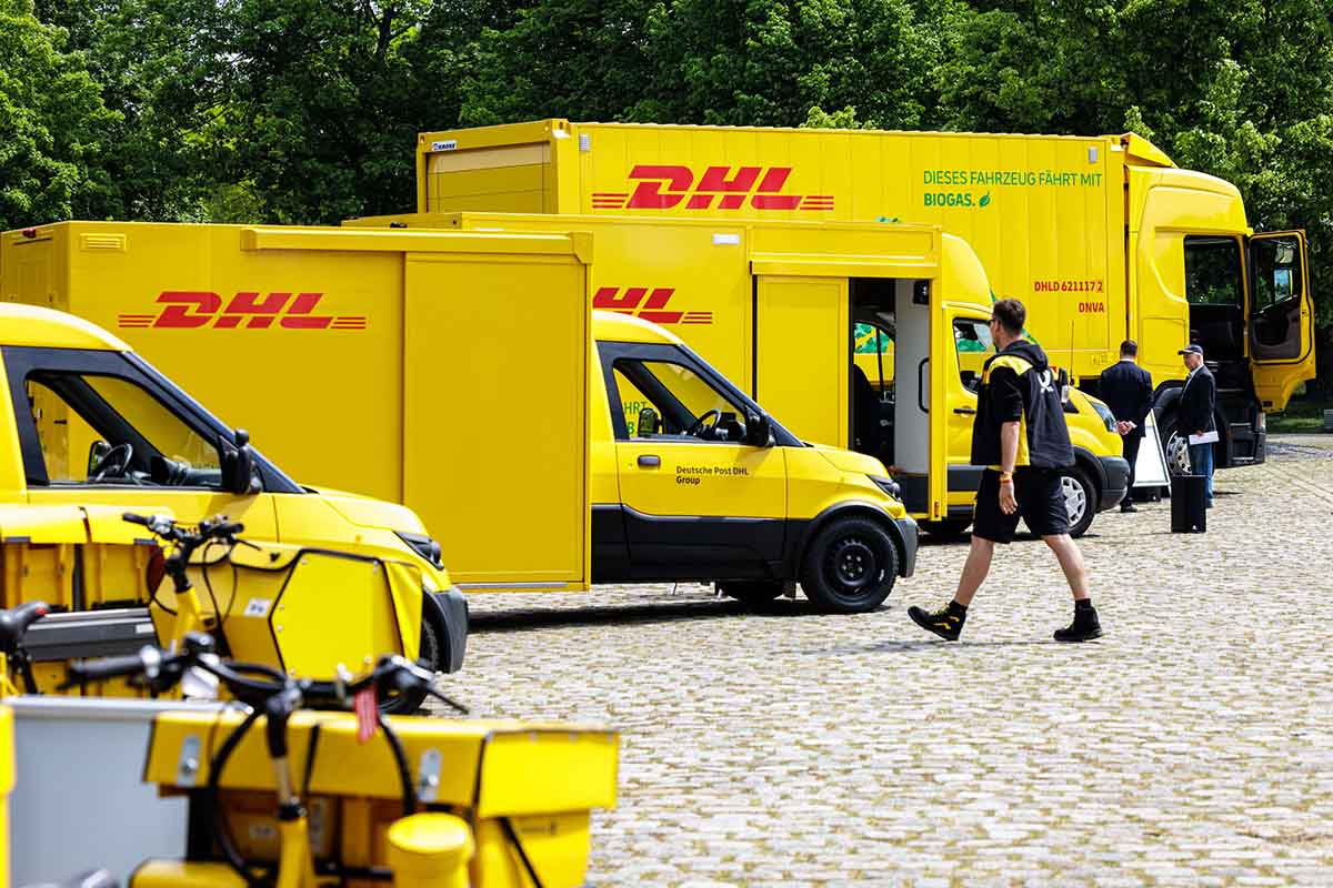 Verschiedene Fahrzeuge der DHL Group sind zu sehen.