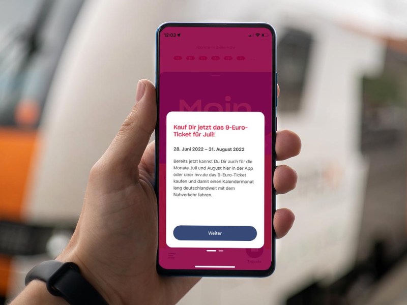 Eine Person hält ein Smartphone, auf dem das 9-Euro-Ticket zu sehen ist.
