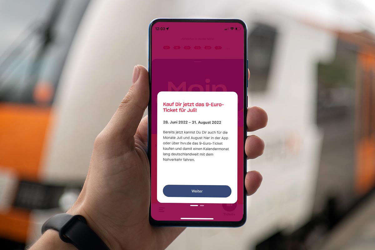 Eine Person hält ein Smartphone, auf dem das 9-Euro-Ticket zu sehen ist.
