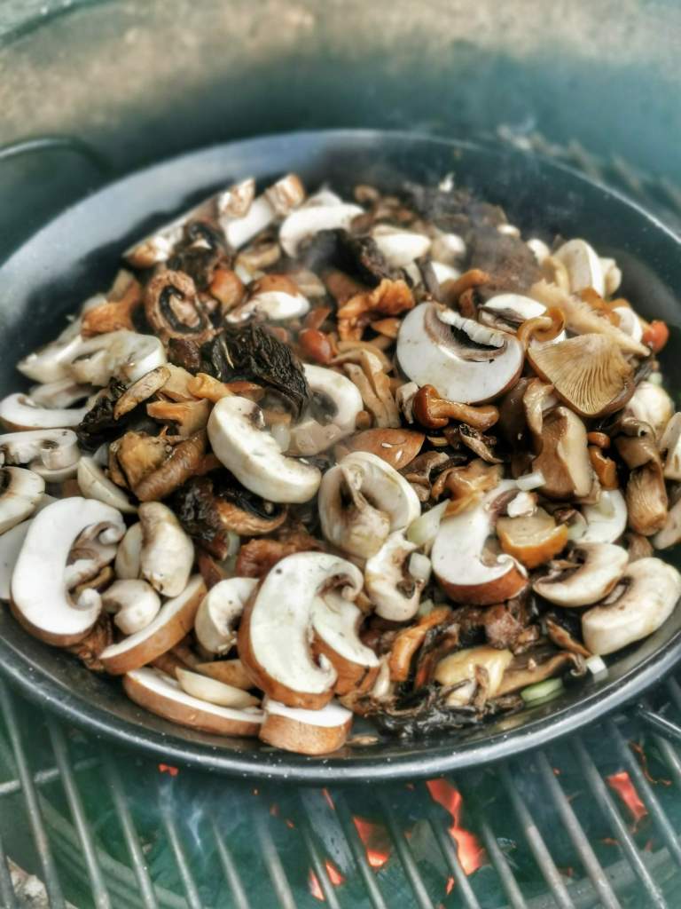 Die 25 besten Grill-Rezepte fürs Camping: Eine Pfanne mit Pilzen auf einem Grillrost