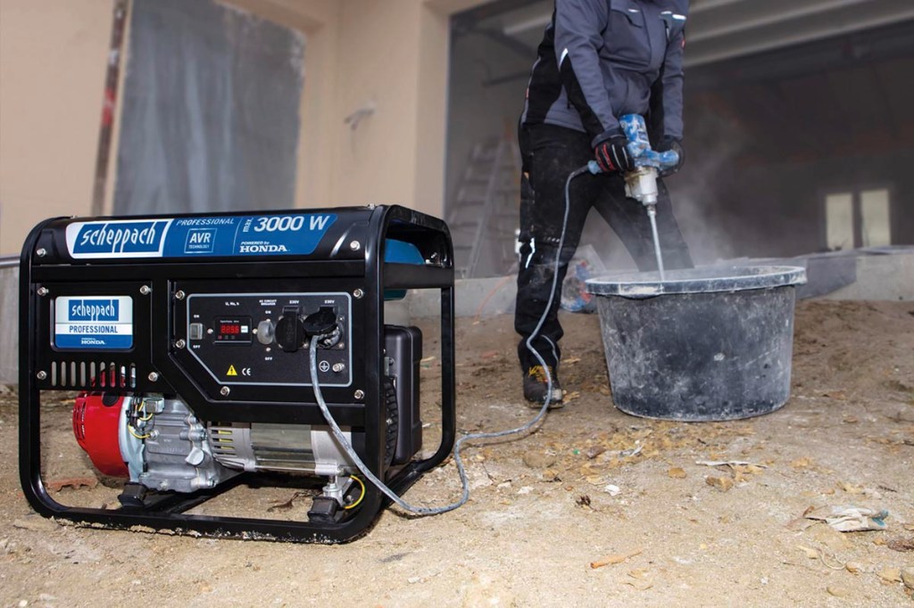 Ein Stromerzeuger mit angeschlossener Handmaschine auf einer Baustelle.