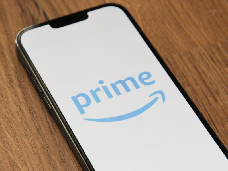Smartphone auf Holz mit Amazon Prime Logo