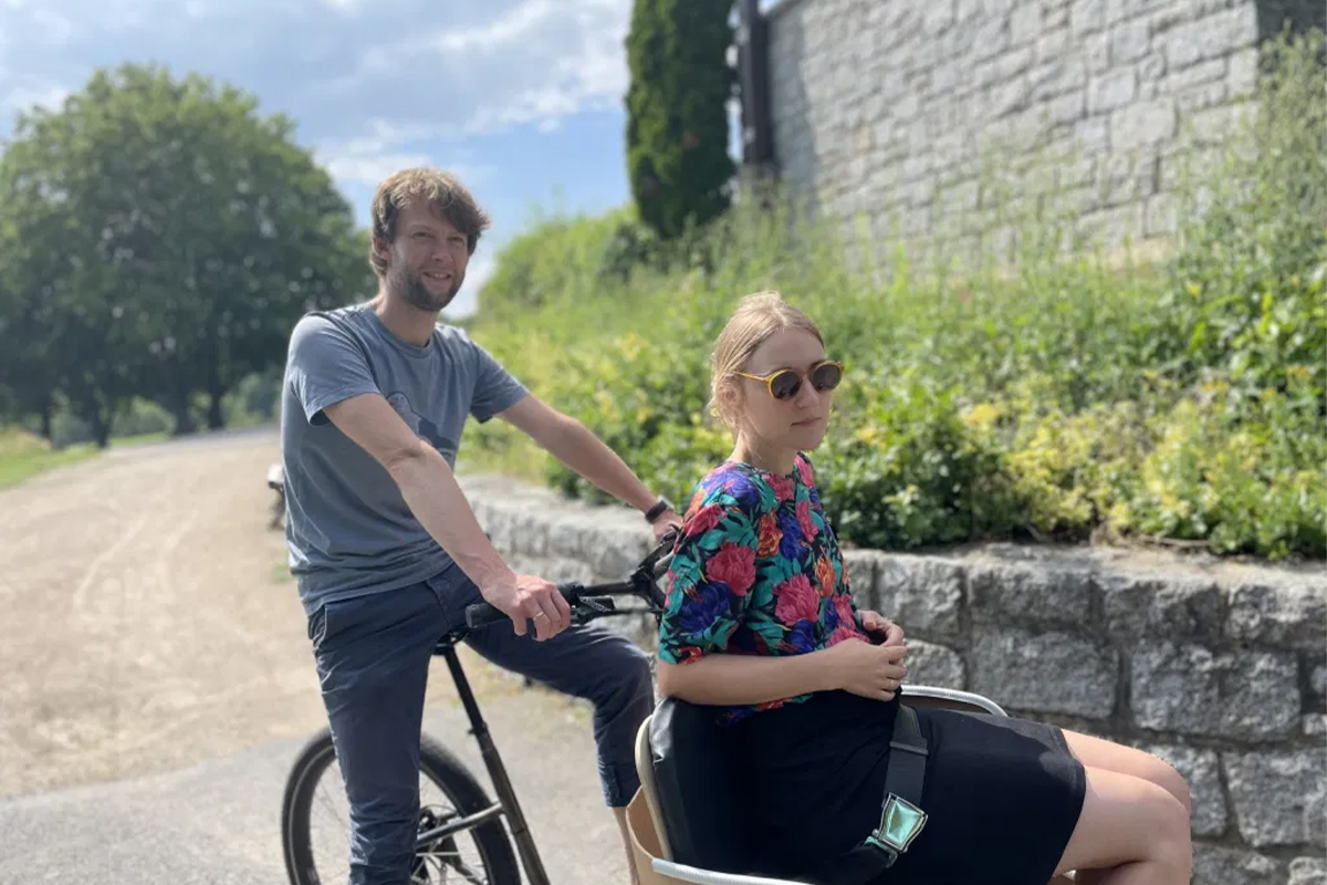 Mäx & Mäleon E-Cargobike: Mann auf Fahrsitz, transportiert eine Frau