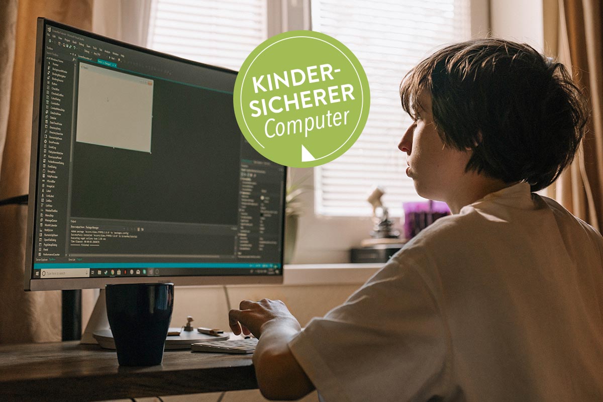 Kind sitzt an einem Schreibtisch vor einem Windows-PC