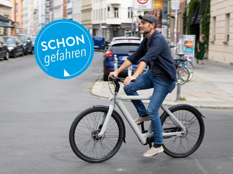 Mann fährt im Straßenverkehr mit City-E-Bike S5 von VanMoof.