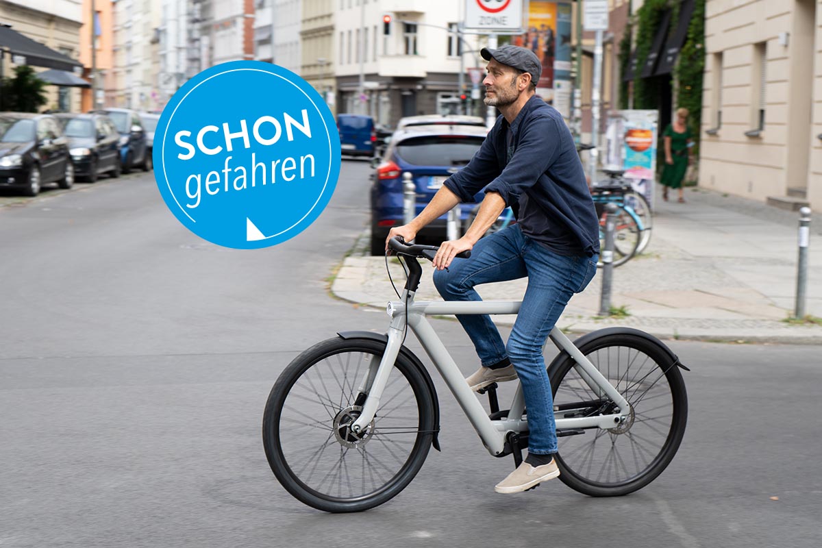 Mann fährt im Straßenverkehr mit City-E-Bike S5 von VanMoof.