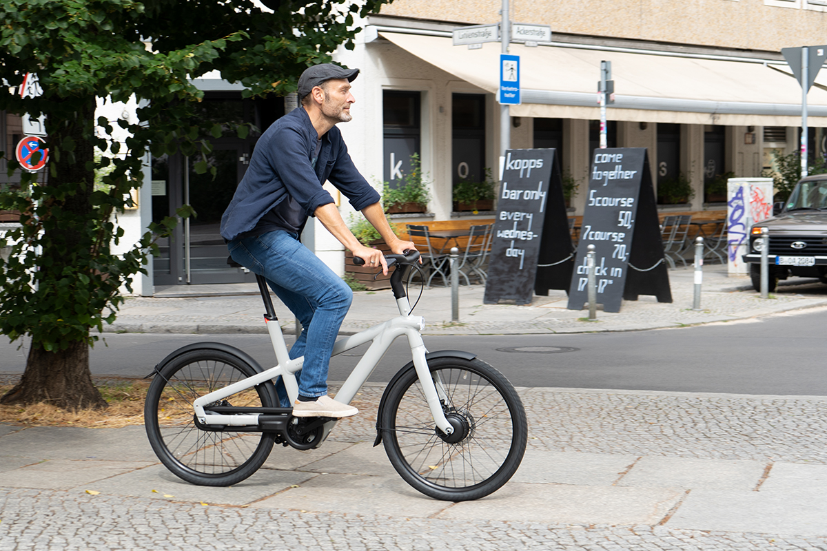 Mann fährt auf City-E-Bike VanMoof A5 durch Stadtverkehr