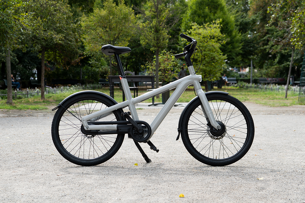 Das City-E-Bike VanMoof A5 in Seitenansicht abgestellt vor einem Park