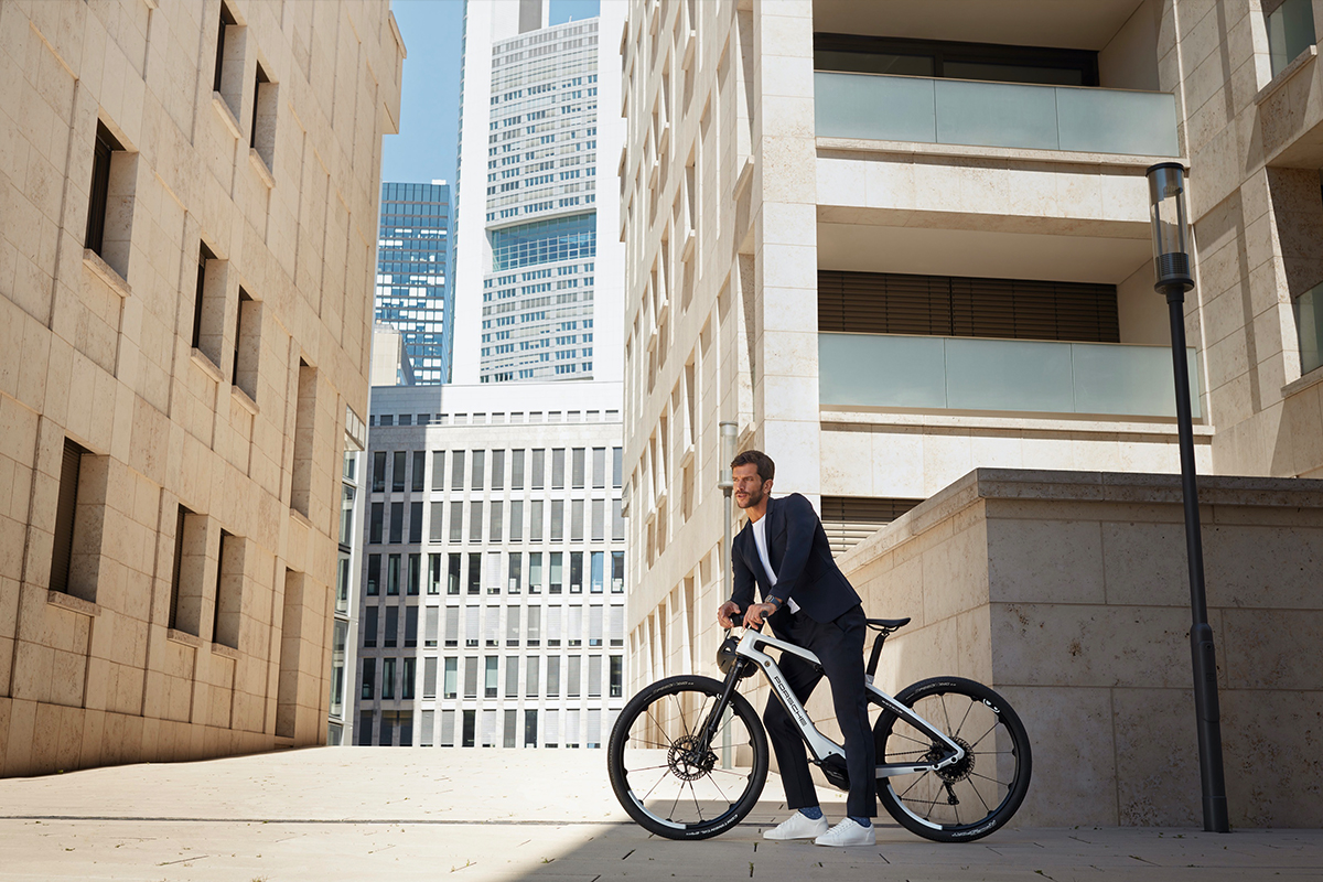 Mann auf Porsche E-Bike in einer Häuserschlucht