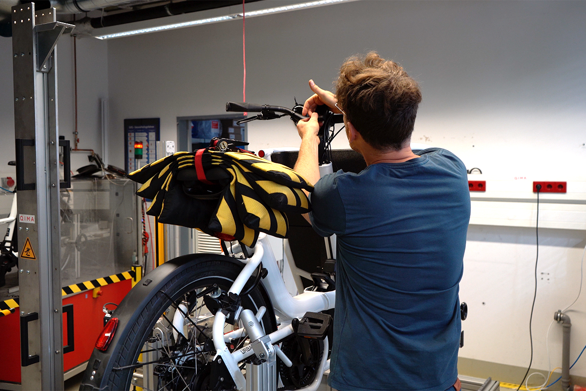 E-Cargo-Bike auf einem Teststand im Labor von Hansecontrol. Inegieru prüft Lenkereinstellungen.