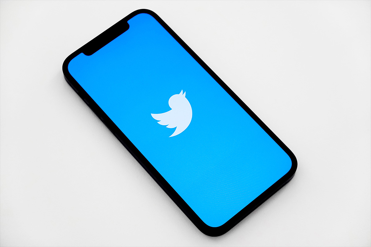 Das Twitter-Logo ist auf einem Smartphone zu sehen.