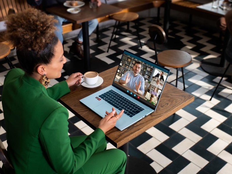 Frau sitzt an einem Tisch mit dem Laptop Acer Swift Edge