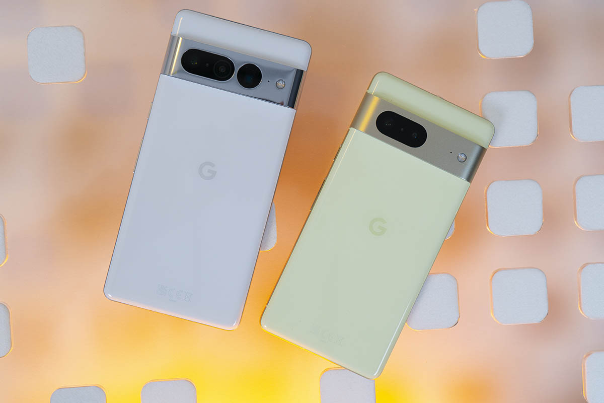 Google Pixel 7 und Pixel 7 Pro nebeneinander auf Glasplatte, gelblich hinterleuchtet