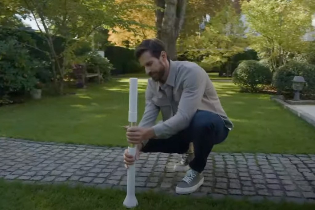 Eine Person steckt eine große Antenne in den Boden.