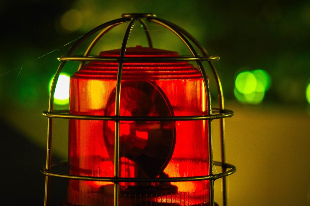 Eine rote Warnlampe unter einem Schutzgitter