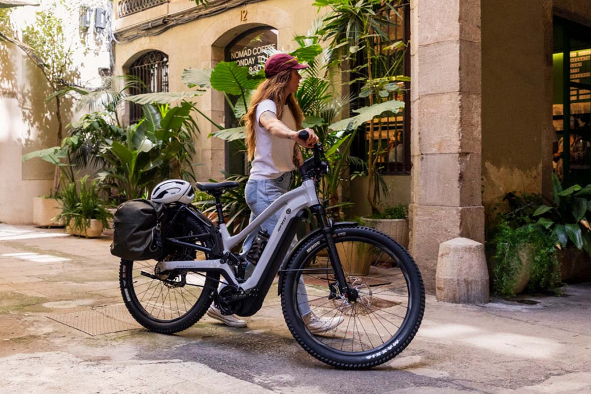 E-Bike Giant Stormguard E+2 mit Frau, die das Fahrrad durch eine Gasse schiebt