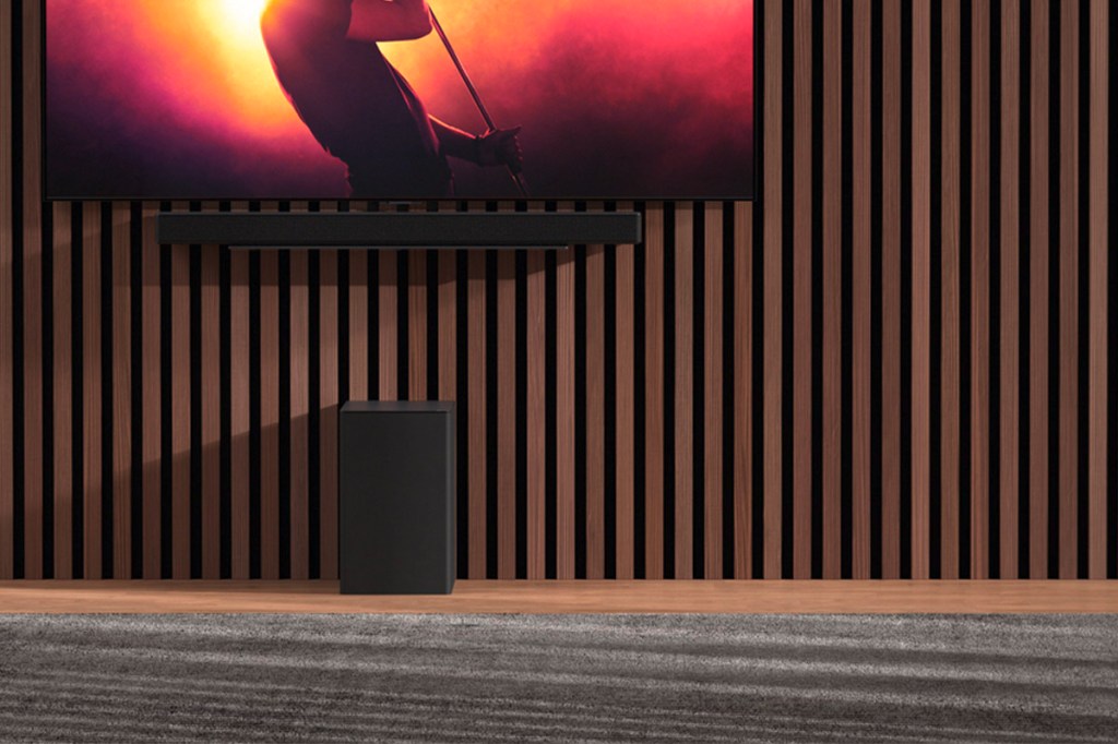 Eine Soundbar und ein Lautsprecher in einer Wohnlandschaft.