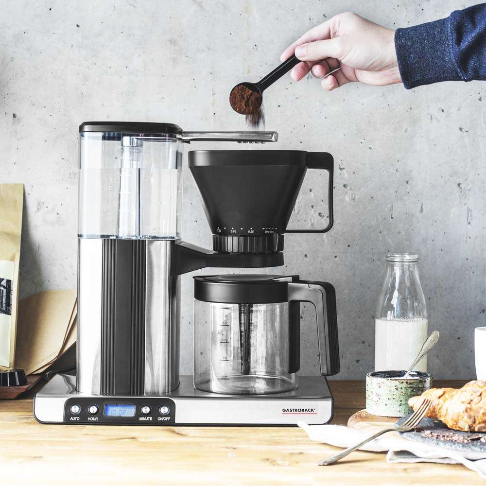 Eine Hand befüllt die Filtermaschine von Gastroback mit Kaffeepulver