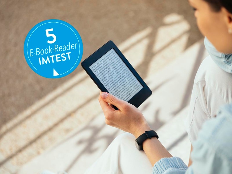 Frau hält in Hand eBook-Reader und schaut drauf mit blauem Button links 5 eBook-Reader IMTEST