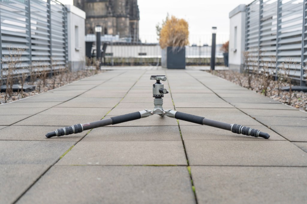 Stativ mit weit gespreizten Beinen auf Gehweg