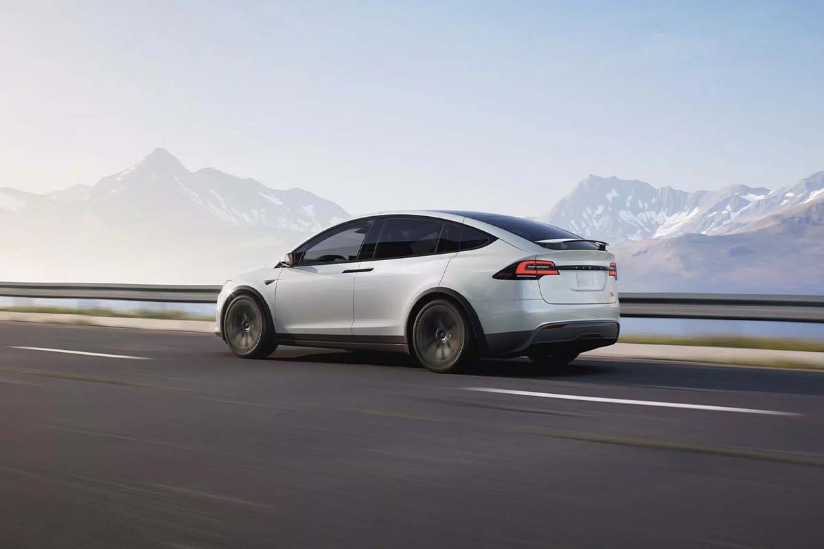 Grafik Tesla Model X auf einer leeren Straße, Bergpanorama im Hintergrund