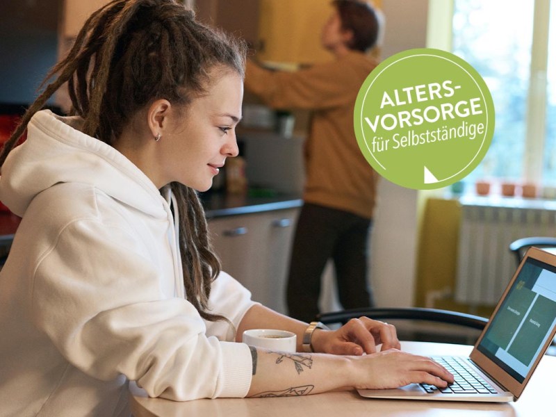 Frau sitzt am Schreibtisch vor einem Laptop
