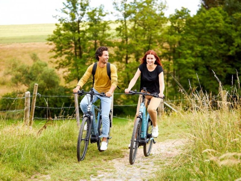 Zwei Menschen fahren auf E-Bikes von Gazelle durch die Natur