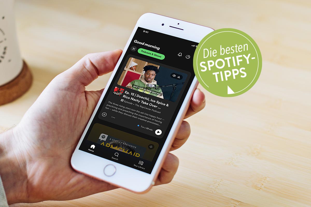 In der Hand gehaltenes Smartphone mit geöffneter Spotify App