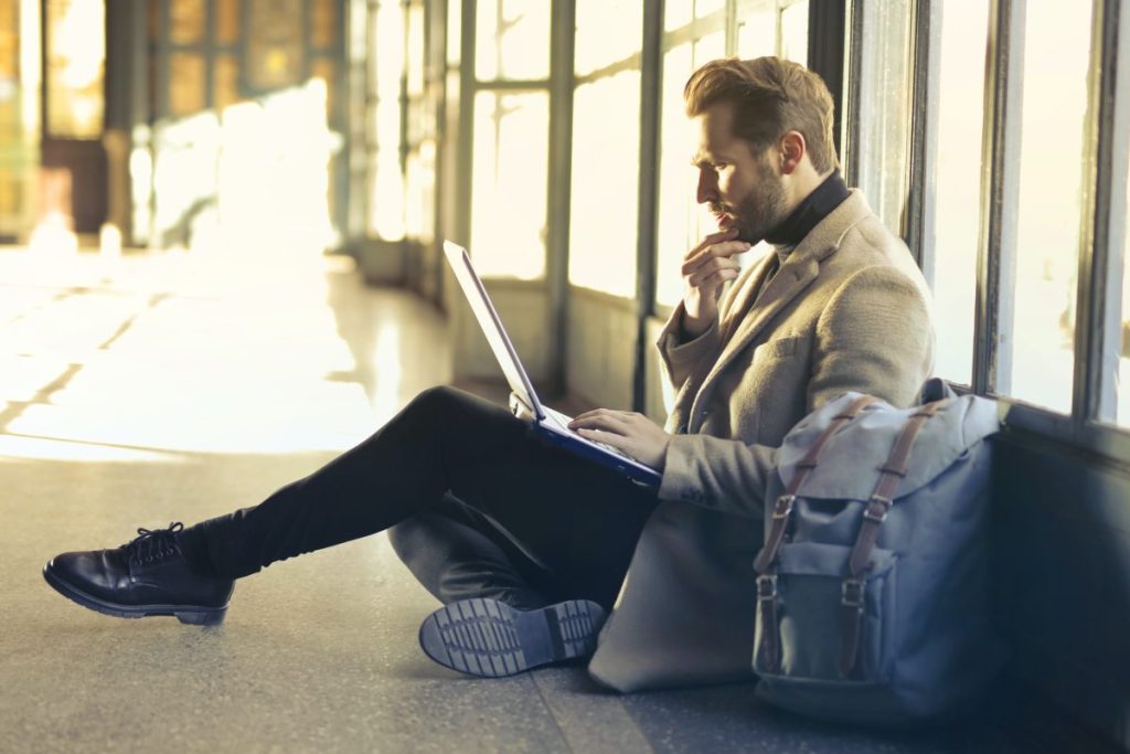 Ein Mann am Bahnsteig am Laptop