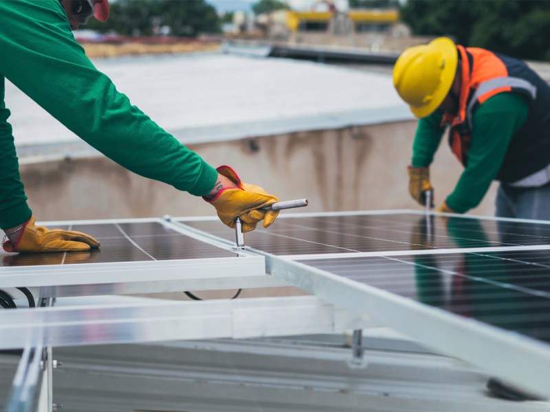 Handwerker schrauben an einer Solaranlage.