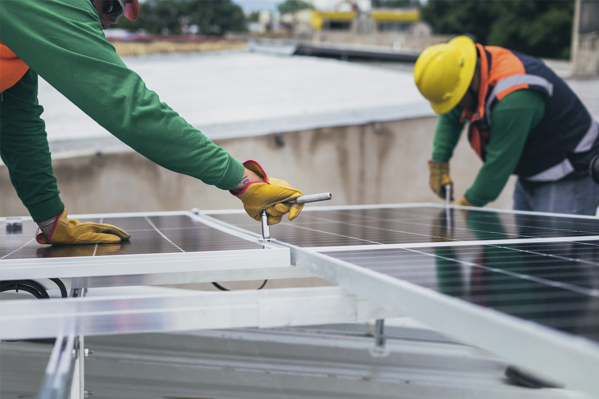 Handwerker schrauben an einer Solaranlage.