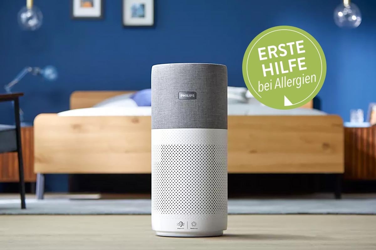 Ein Luftreiniger von Philips aufdem Boden vor einem Bett stehend.