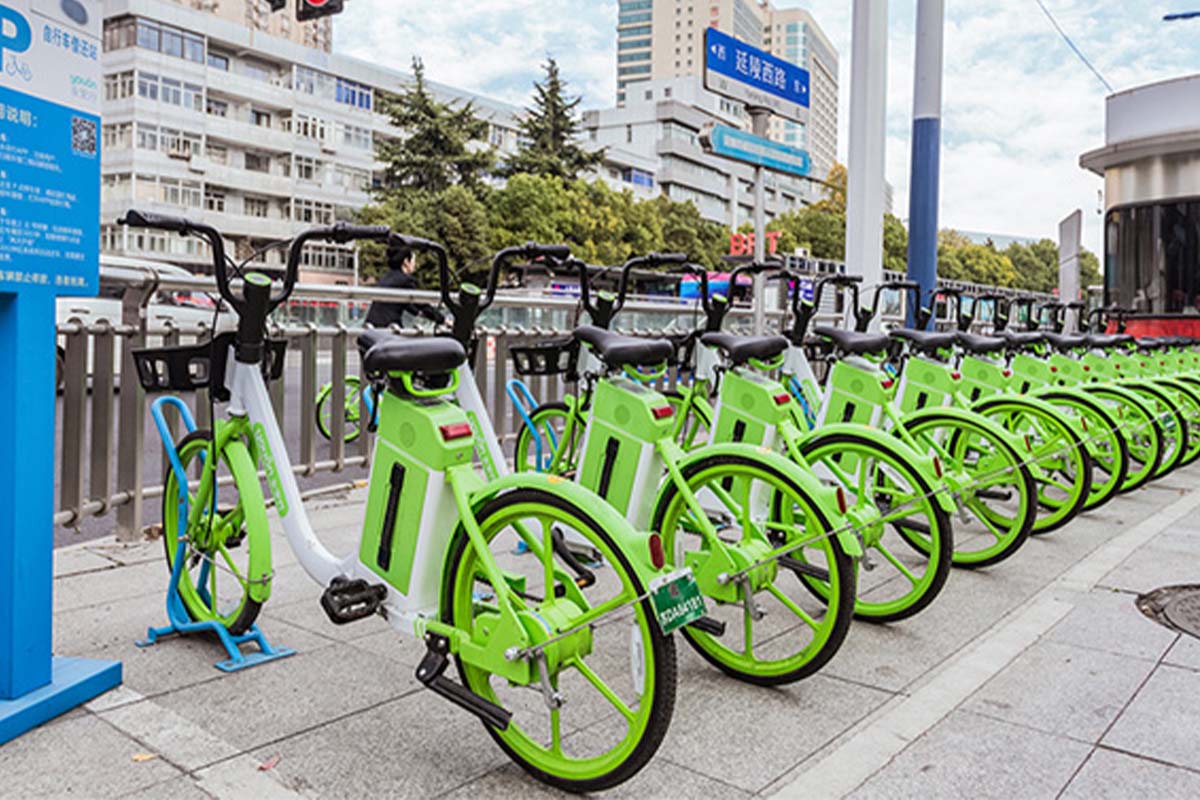 Viele grüne Fahrräder an einer Mietstatioin in China.