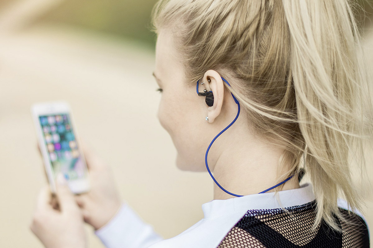 Eine Frau trägt Bluetooth-Kopfhörer von Hama beim Joggen.