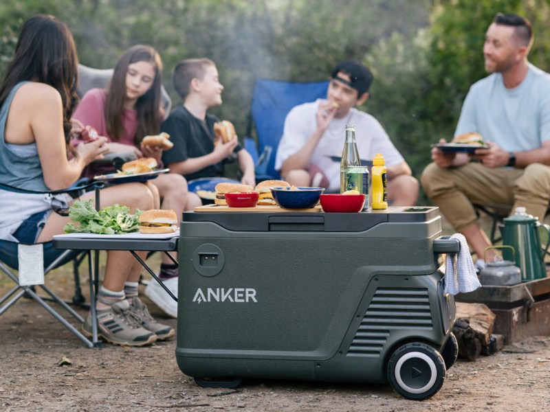 Eine Familie sitzt am Lagerfeuer, davor der Anker EverFrost.