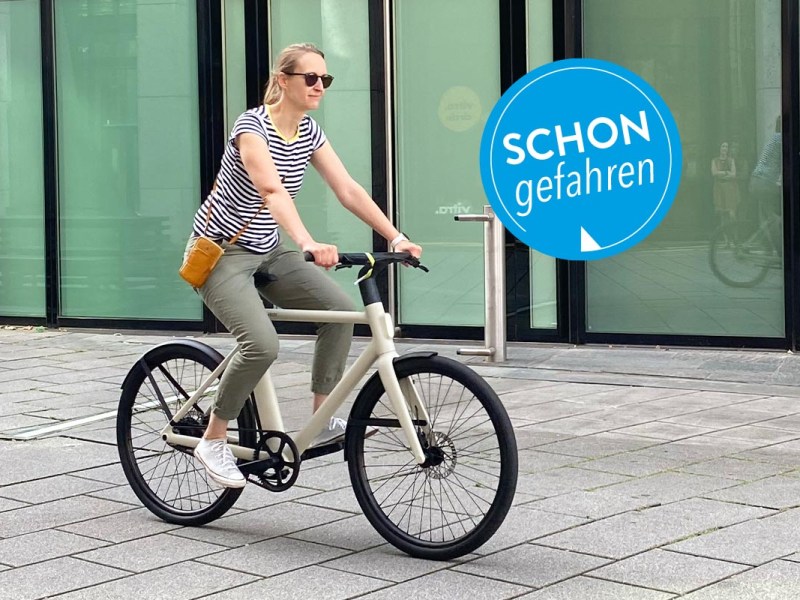 Frau auf einem E-Bike auf Gehwegplatten.