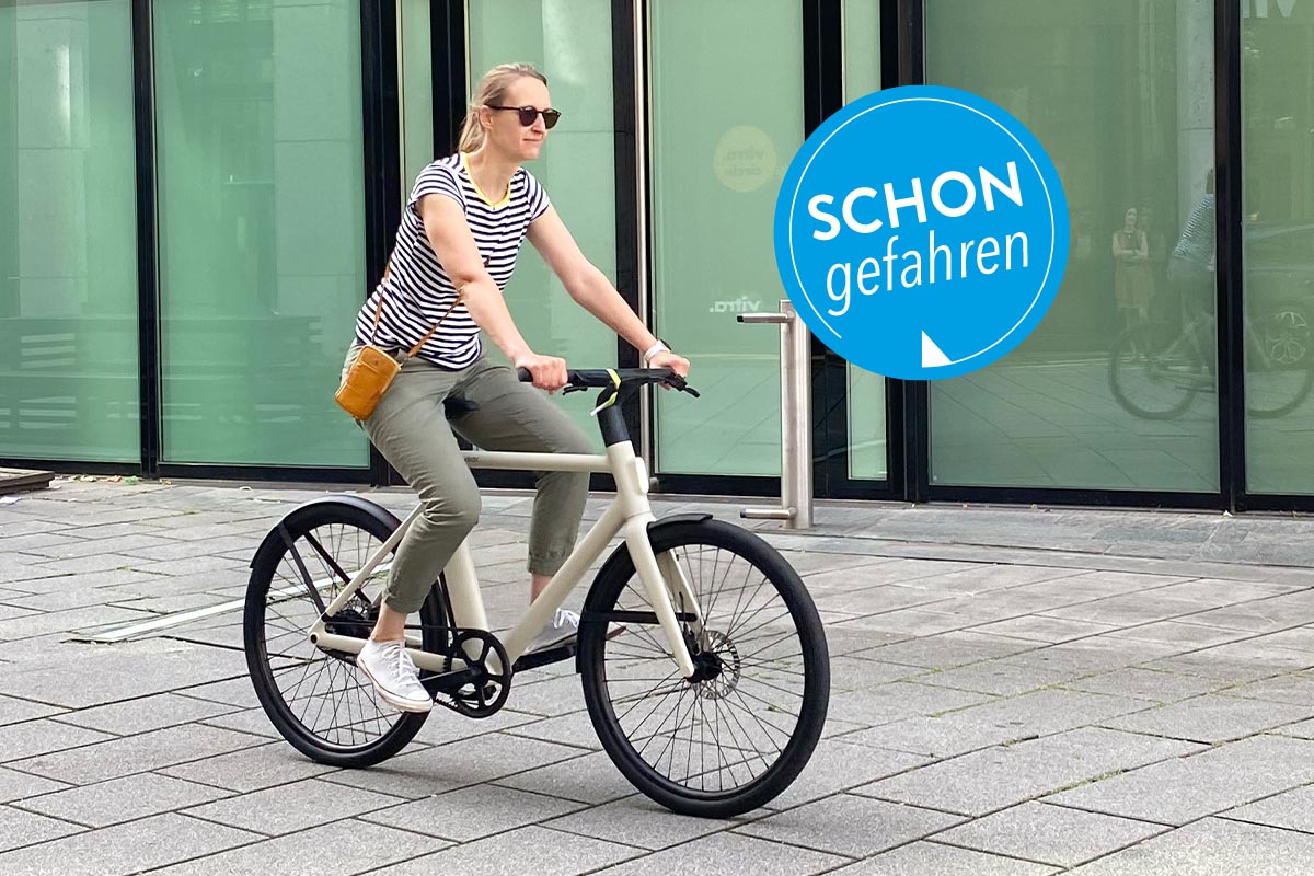 Frau auf einem E-Bike auf Gehwegplatten.