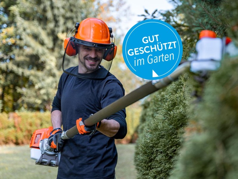 Ein Gärtner, der eine Hecke schneidet