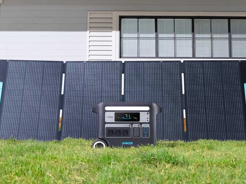 Eine Anker Powerstation und das neue Solix PS400 Solarpanel in einem Garten.