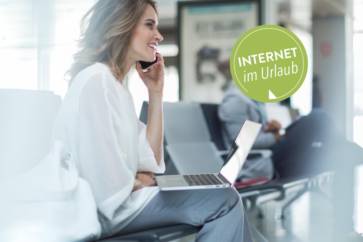 Eine Frau sitzt mit Smartphone und Notebook am Flughafen