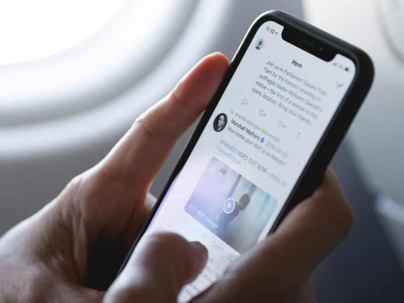 Eine Person scrollt auf einem Smartphone auf Twitter.